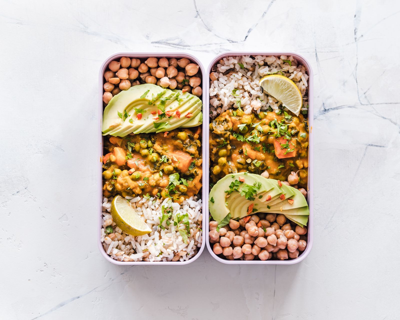 Dos táperes con garbanzos, arroz y aguacate listos para la semana
